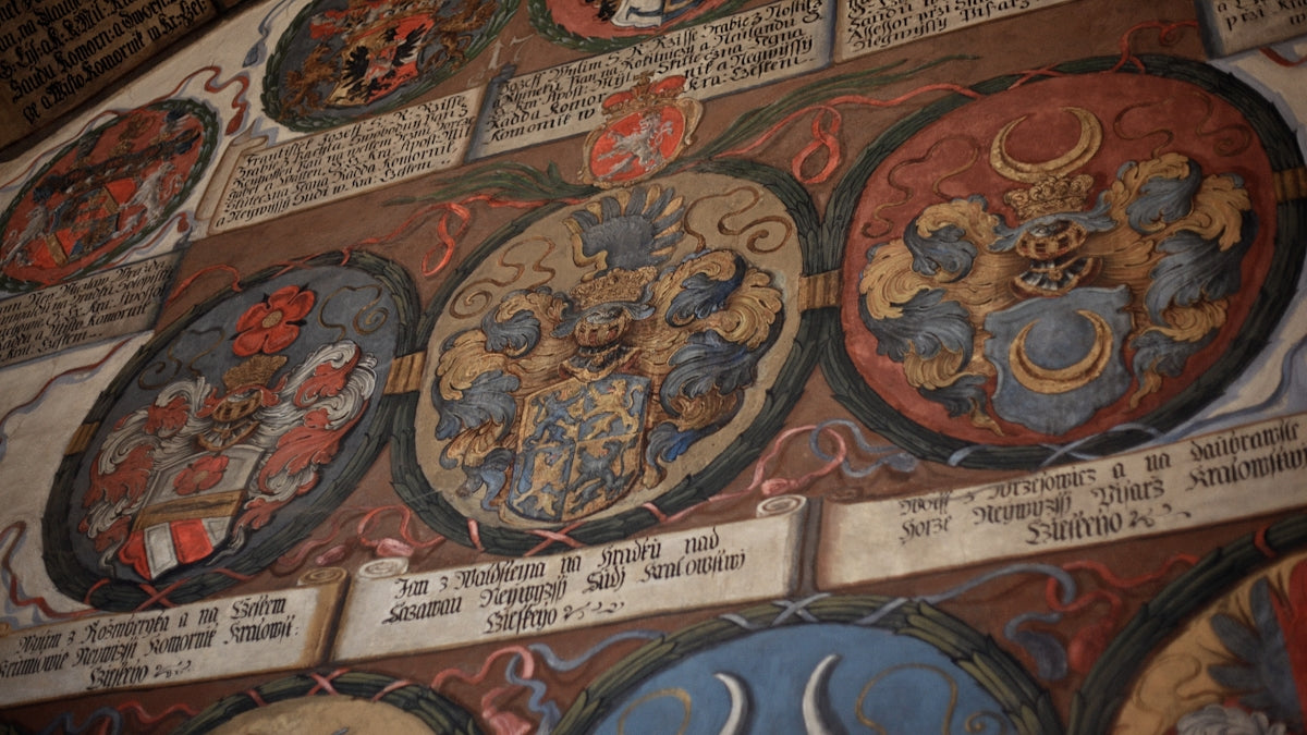 Three oval medieval coats of arms with intricate details.